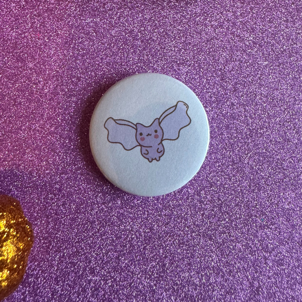 Pastel bat badge on a glittery pink background