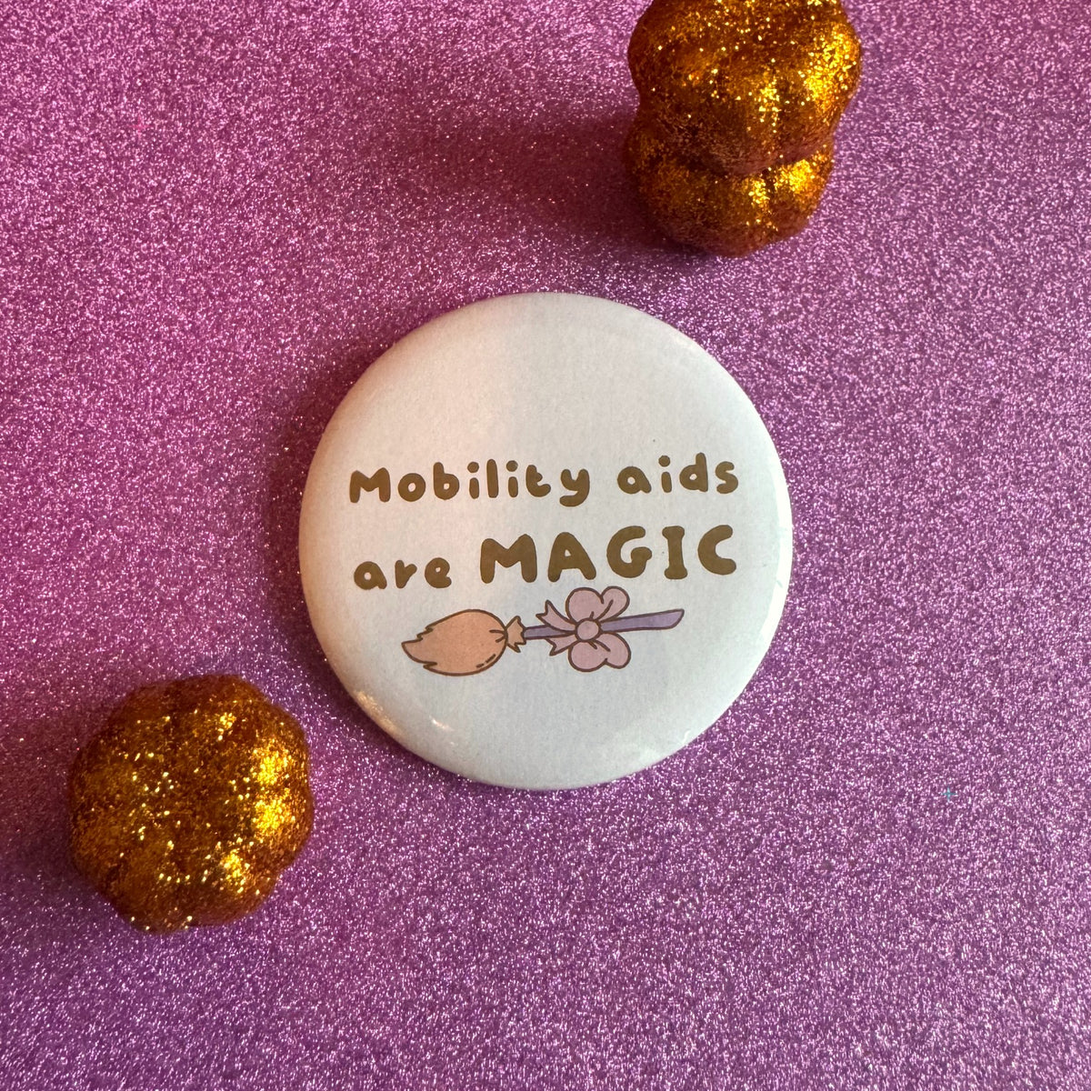 Mobility aids are MAGIC slogan badge on a glittery pink background