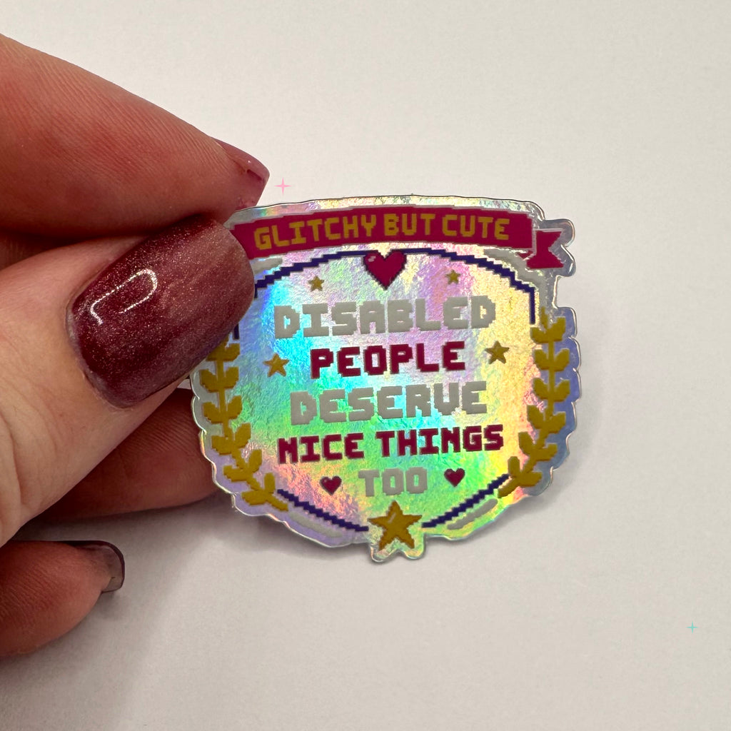 Disabled People Deserve Nice Things Too holographic sticker held in a hand for scale