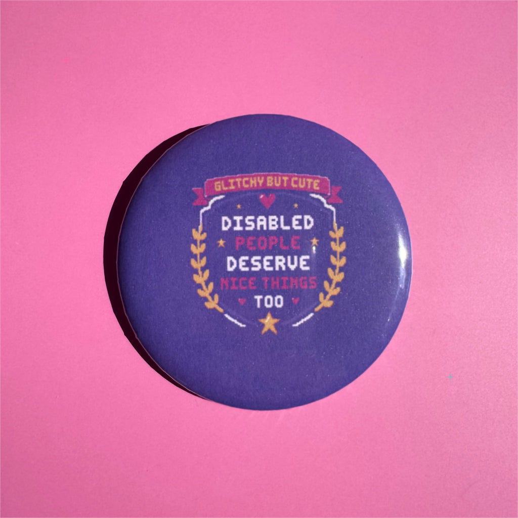 58mm purple Disabled People Deserve Nice Things Too button badge on a pink background