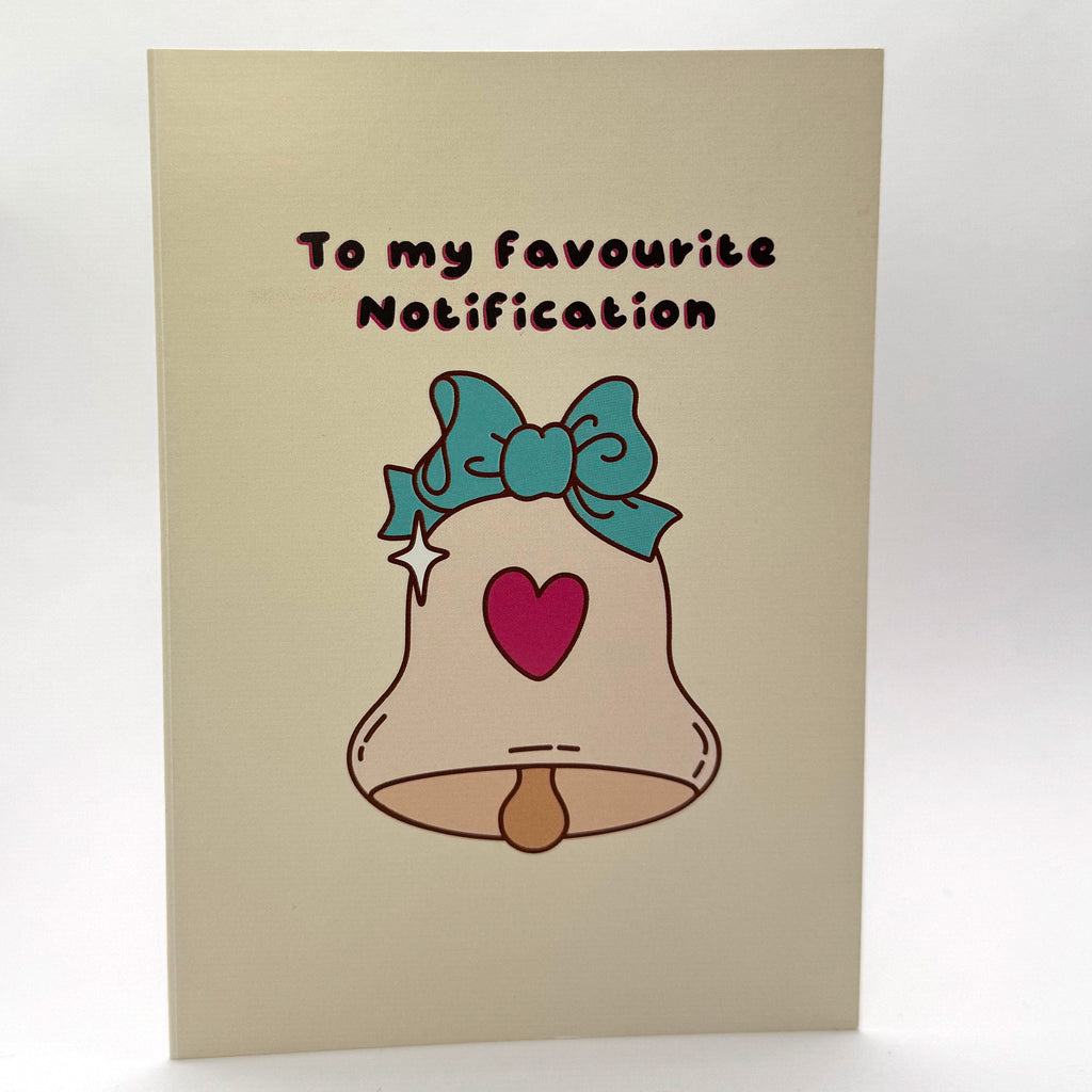 To My Favourite Notification A6 Christmas card with a teal bow and pink heart illustration.