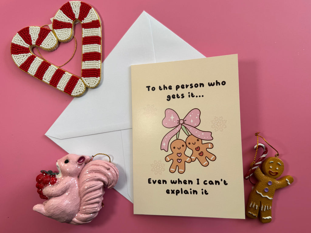 To the Person Who Gets It Christmas card and envelope on pink paper with festive decorations.