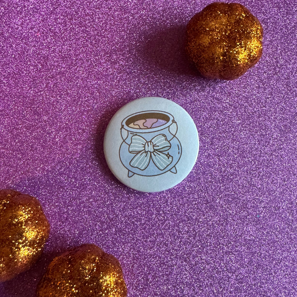 Hexecutive Dysfunction cauldron 32mm badge on glittery pink background