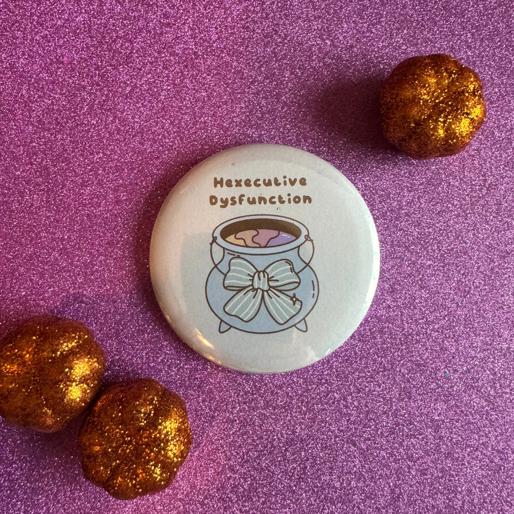 Hexecutive Dysfunction cauldron slogan 58mm badge on glittery pink background