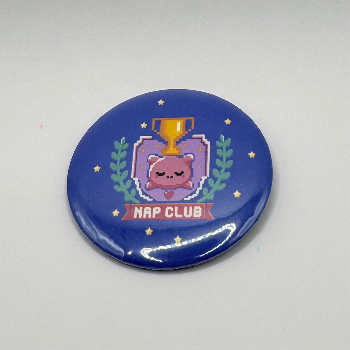 Small 32mm Nap Club button badge with sleeping pillow and trophy design