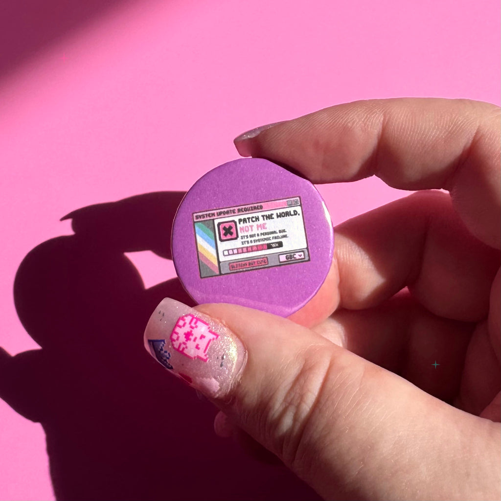 32mm purple Patch the World, Not Me button badge held between fingers for scale