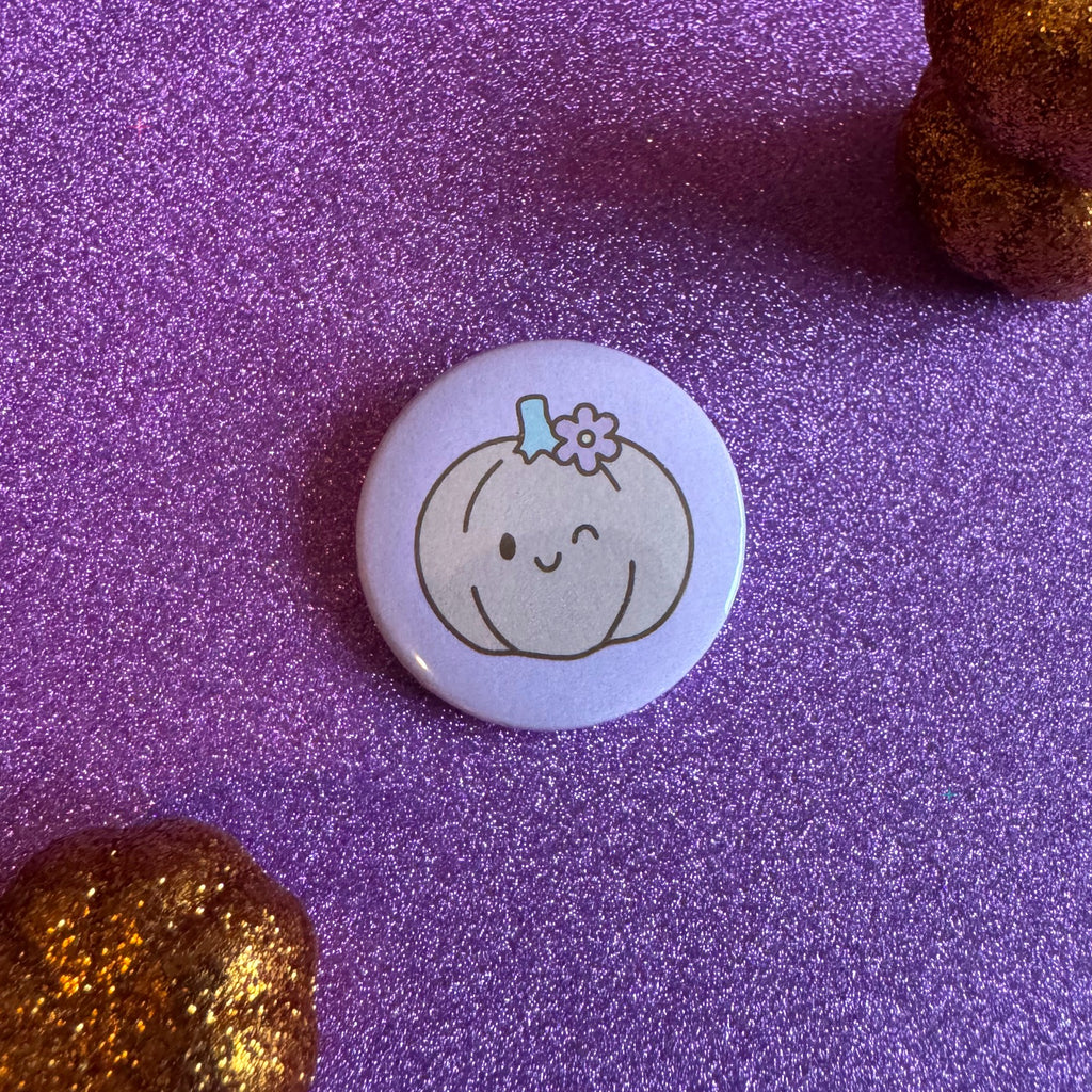 Smiling pumpkin badge on a glittery pink background