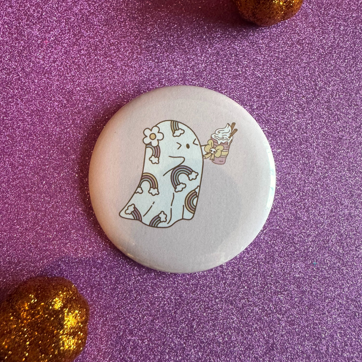 Ghost holding a pumpkin spice drink badge on a glittery pink background