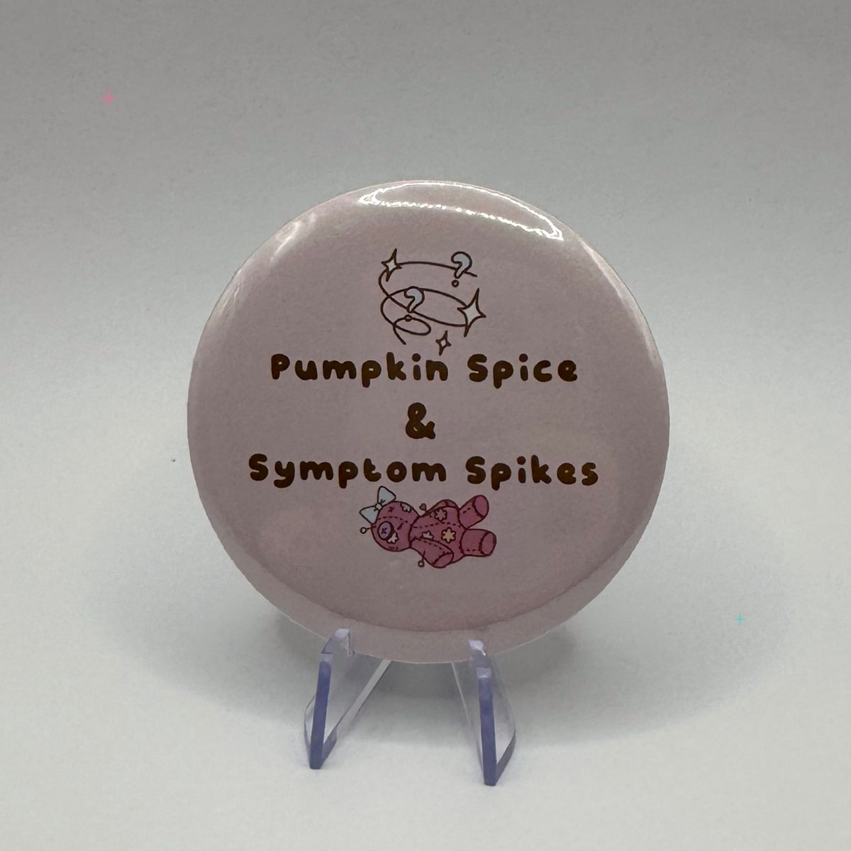 58mm Pumpkin Spice and Symptom Spikes slogan badge on a white background