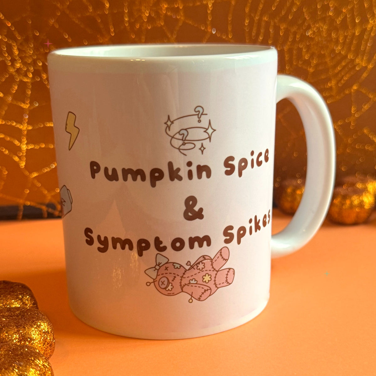 Pumpkin Spice and Symptom Spikes slogan mug styled with autumn decor