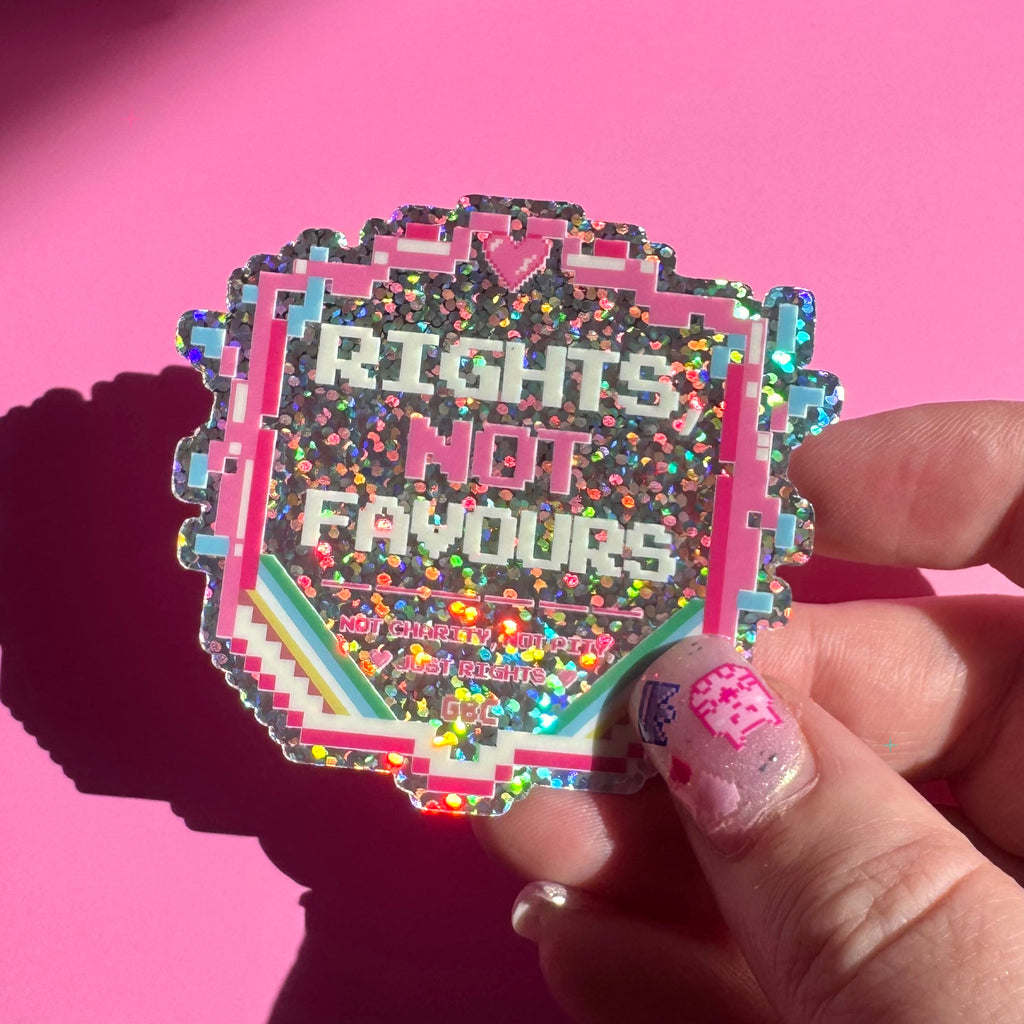Rights, Not Favours glitter holographic sticker held between fingers to show its size and sparkle